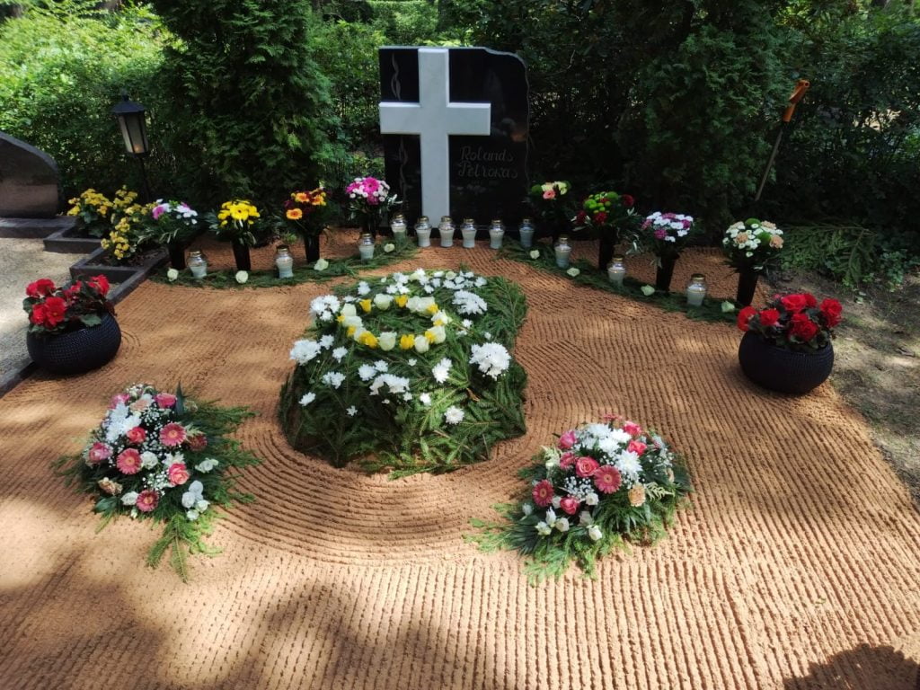 kapa noformēšana urnu apglabāšanai ar ziediem.